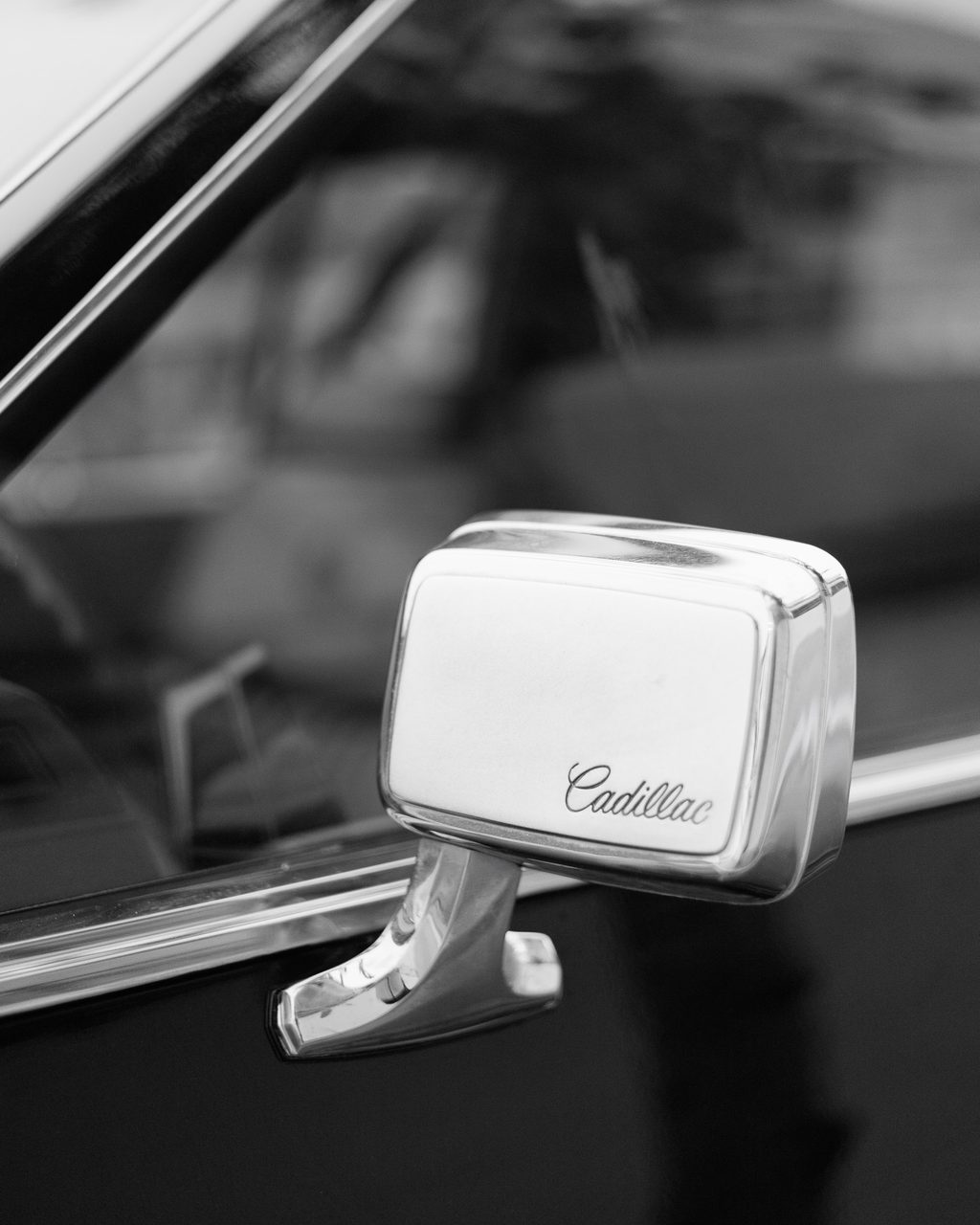 Retrovisor cromado de un Cadillac clásico con el logotipo grabado, capturada en Oropesa, Castellón.