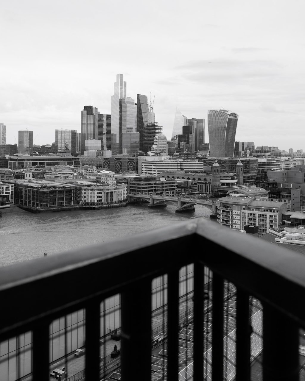Skyline de la City de Londres visto desde la terraza del Tate Modern, con rascacielos, el río Támesis y un cielo nublado.