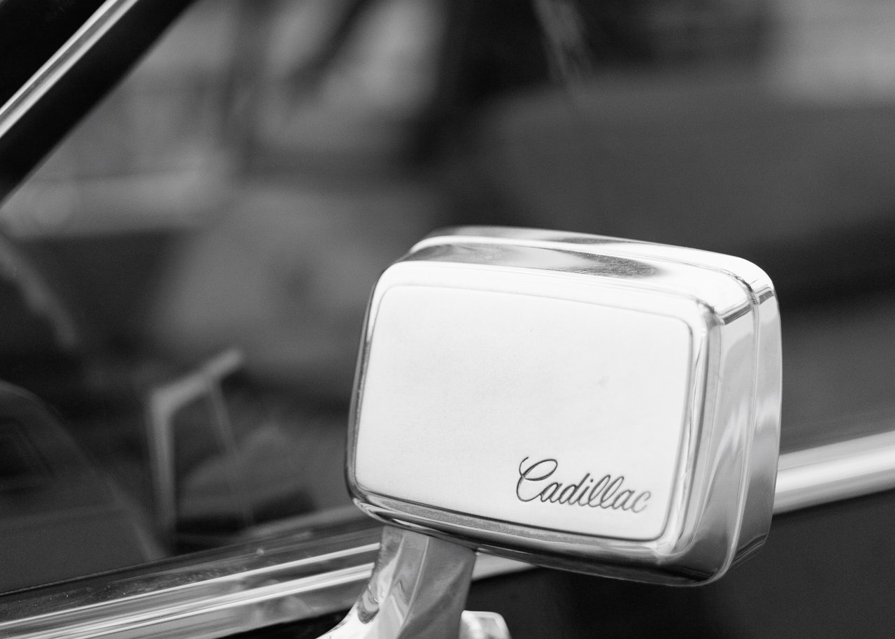 Retrovisor cromado de un Cadillac clásico con el logotipo grabado, capturada en Oropesa, Castellón.