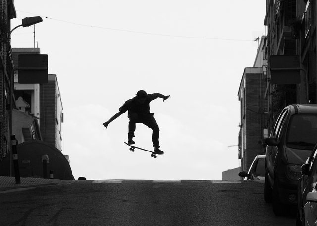 Silueta de un skater saltando sobre una calle en pendiente de Burjassot, Valencia
