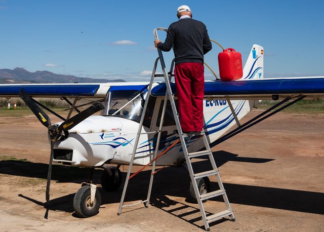 Piloto repostando un ultraligero con garrafa roja en un aeródromo de Valencia